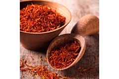 Image Bowl filled with saffron, and a spoon with saffron next to it.