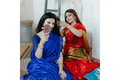 Image an indian woman combs another indian woman's hair