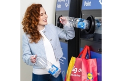 Image scottish woman return plastic bottle at a reverse vending machine part of Lidl pilot in Glalsgow