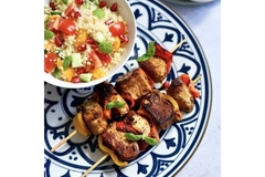 Image A plant-based meat dish on a wooden sticks kept on a white and blue flowery plate.