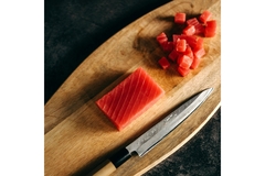 Image A sushi chef slicing tuna.