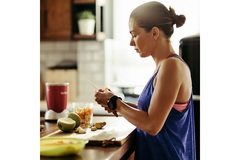 Image Athletic woman making a sports nutrition smoothie.