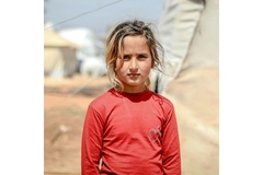refugee girl next to tent