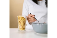 Woman eats fiber-fortified cereal high in prebiotic fiber.