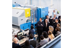 Image People standing around digital watermaking technology machine.