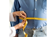 Image Overweight man whose waist is being measured.