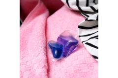 Image Laundry pod lying on pile of clothing.