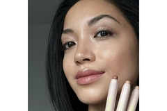 Image Woman holds three glowy stick by her cheek.