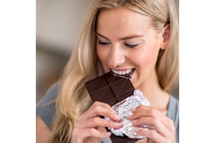 Image Woman eating a bar of chocolate.