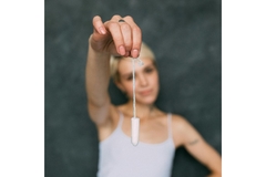 Image A woman holding a tampon.