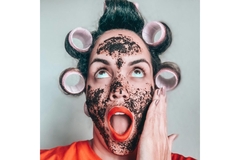 Surprised woman with face mask and hair rolls.