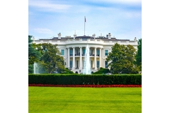Image The White House from across the green lawn in the summertime as the fountain shoots high into the air.
