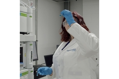 Image A scientists holding up something to the light.