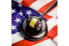 A gavel is placed on a stand on a US flag.