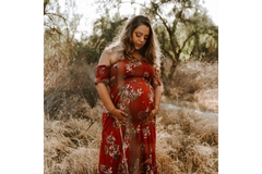 A pregnant women stares at her belly in the desert.