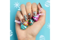 Image A hand with press on nails holding Hershey's Kisses.