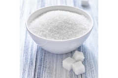 Sugar cubes are placed next to a bowl of sugar.