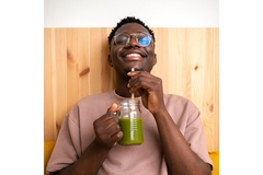 Image Man drinking juice with bamboo straw.