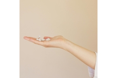 Image White pills in a hand.