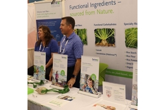 People are standing by a table at the trade show.