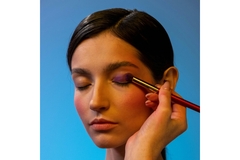 Image woman get eyeshadow applied on her eyelids.