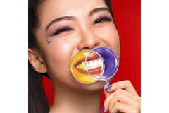 Image Woman brushing her teeth with purple toothpaste