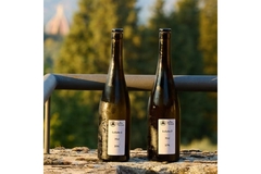 Image Two bottles of Japanese rice wine are standing on a railing.
