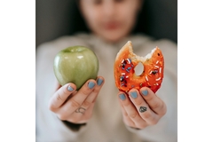 Image Girl holding up a donut and an apple