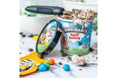 Ben and Jerry's ice cream in a colorful cup with a cow's image on it.