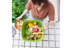 Image Top view of a woman throwing food waste in the dustbin.