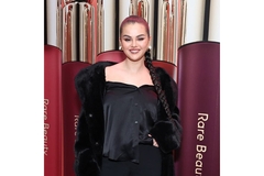 Image Selena Gomez standing in front of Rare Beauty blush cardboard cut outs.