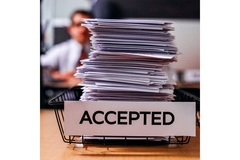 Image Stack of paper files in a basket marked Accepted.