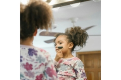 Image little girl using a rolling device on her cheek