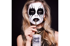 A woman with corpse paint on her face and drinking Liquid Death.