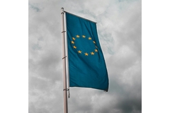 Image EU flag against grey sky.