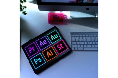 Image Pictures of Adobe apps sitting on a desk.