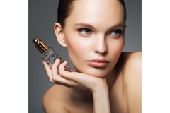 Image A woman posing and holding a bottle of fragrance.
