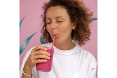 Woman drinking a smoothie full of essential vitamins