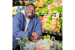 Smiling man in supermarket aisle