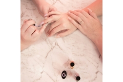 Image A hand painting someone else's nails.