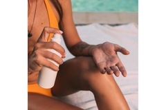 Image woman by pool applies sun block