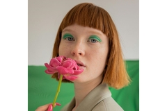 Image Woman holds flower to her mouth