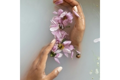 Image Hands holding flower petals in a bath