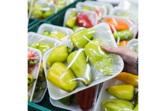 Holding fruit in plastic wrapping.