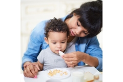 Image Mother feeding young child.