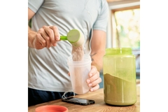 Person making a protein smoothie with plant-based protein.