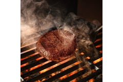 Image Cultivated meat patty on a grill.
