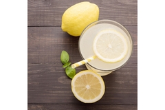 Image Lemonade with fresh lime slice on a wooden board.