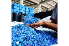 Image worker's hands holding plastic resin pellets in a plastic production facility