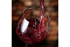 Image freeze motion of red wine pouring into glass